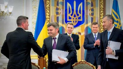 L-R: Chevron's General Manager for Europe Derek Magness and Ukraine's Ministrer of Ecology and Natural Resources Eduard Stavytsky shake hands during a ceremony in Kiev on November 5, 2013